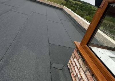 Flat roof with black waterproofing material and window