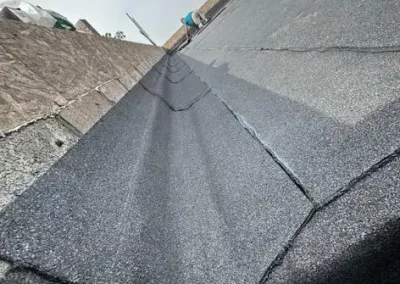 Worker installing asphalt roofing sheets