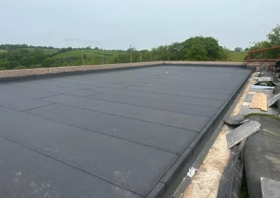 Flat rubber roof installation on country house.